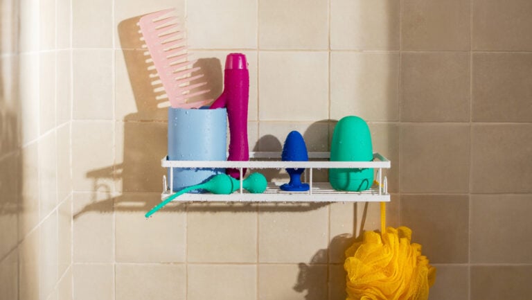Des toys sont placés dans une douche à côté des produits d'hygiène, pour illustrer l'existance du sextoy waterproof.