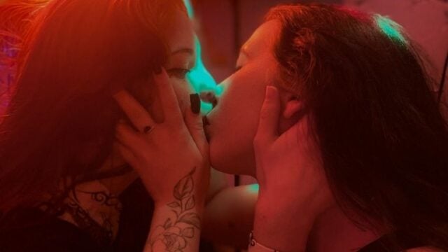 Deux femmes s'embrassent en rave party, prêtes à vivre une folle histoire érotique.