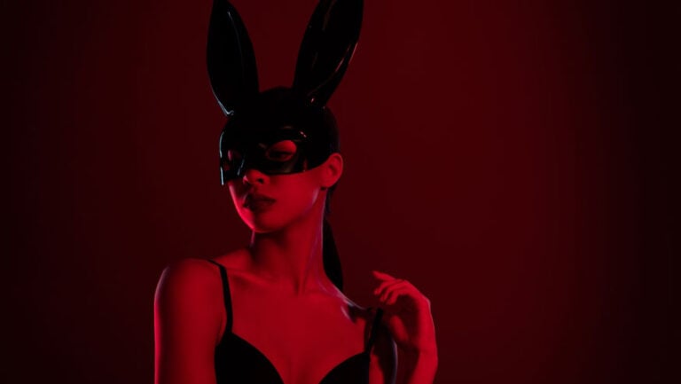 Une femme porte un masque en latex avec des longues oreilles de lapin, prête pour des jeux BDSM.