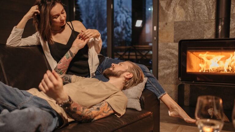Un couple est prêt à vivre une histoire érotique à côté de la cheminée.