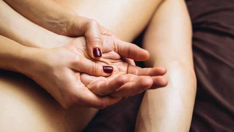 Les huiles de massage sont utilisées sur une main détendue.