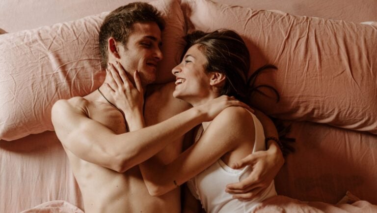 Deux personnes sont au lit, le consentement au cœur de leur discussion.