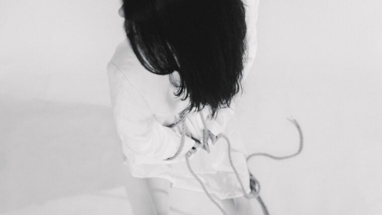 Une personnes est attachée avec une corde, et pratique le bdsm avec un safeword.
