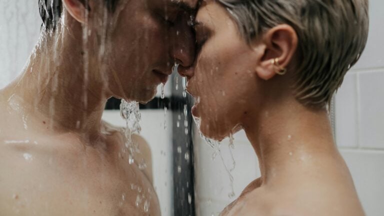 Deux personnes s'embrassent passionnément, prête pour le sexe sous la douche.