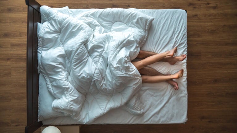 Deux paires de jambes sont vues du haut, le reste des corps sous un draps, pour illustrer les rêves sexuels.